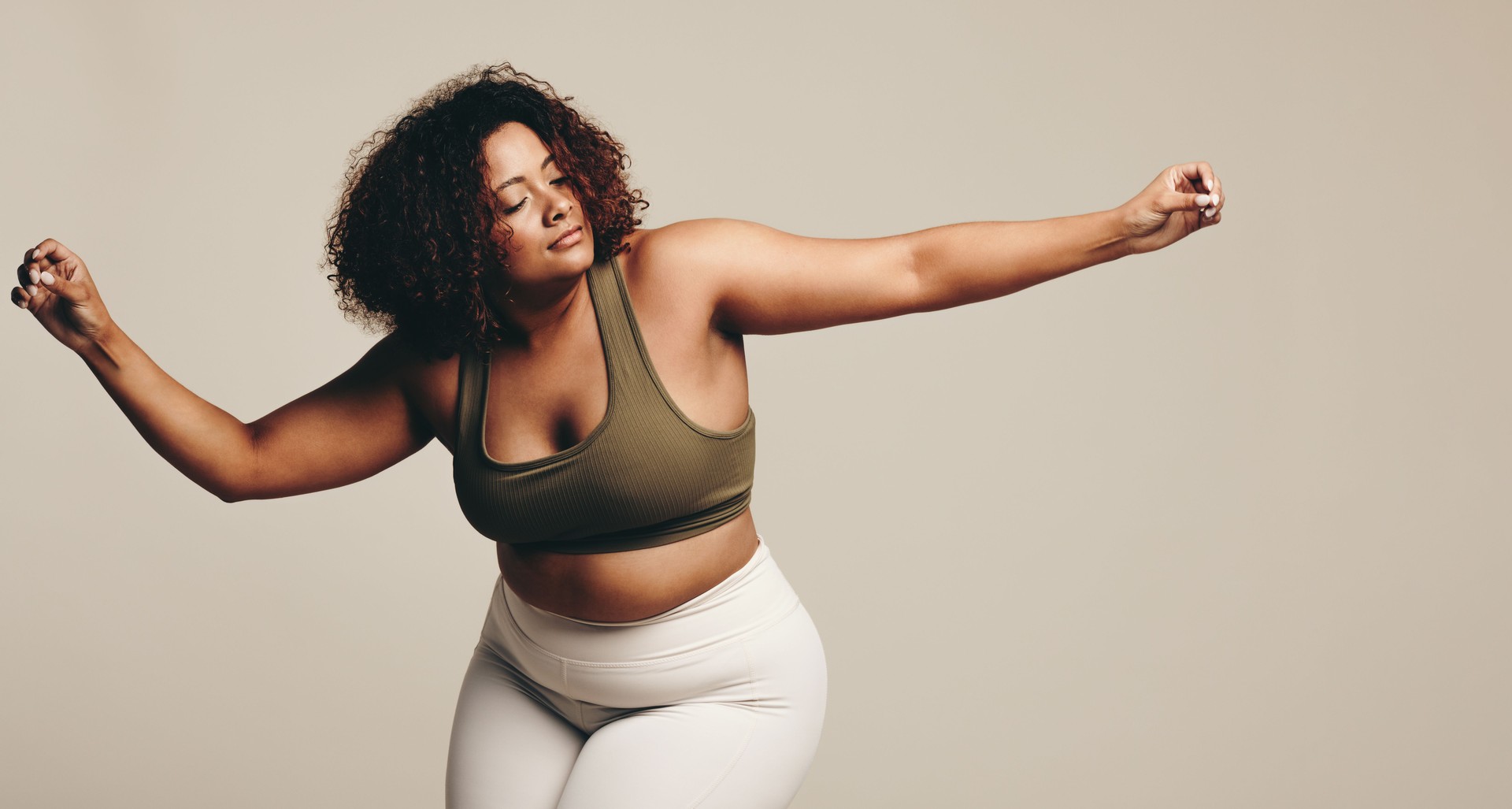 Confident young woman dancing and finding her flow in a studio