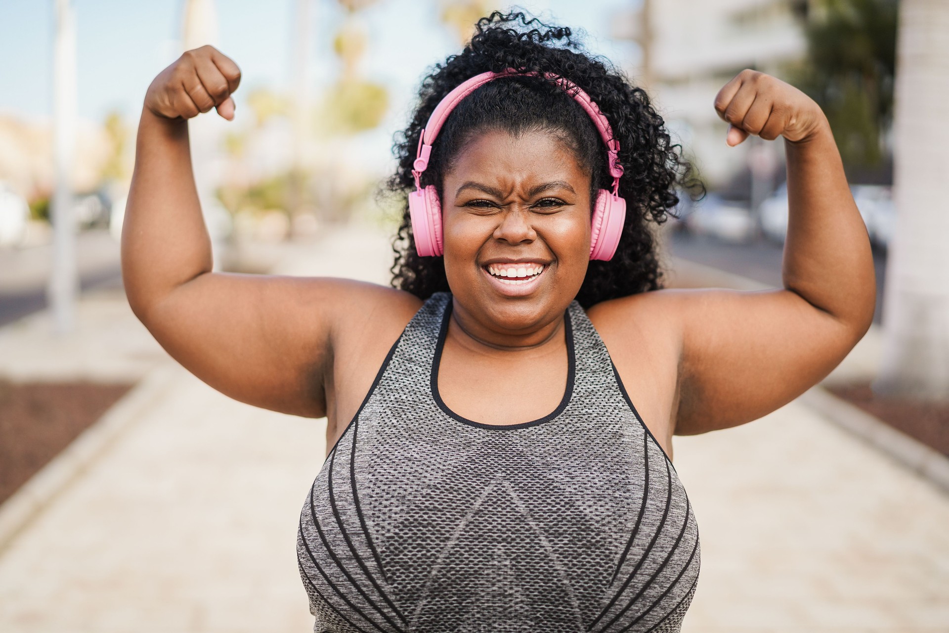 Happy curvy african woman doing sport workout routine outdoor - Fitness and healthy lifestyle concept - Focus on face