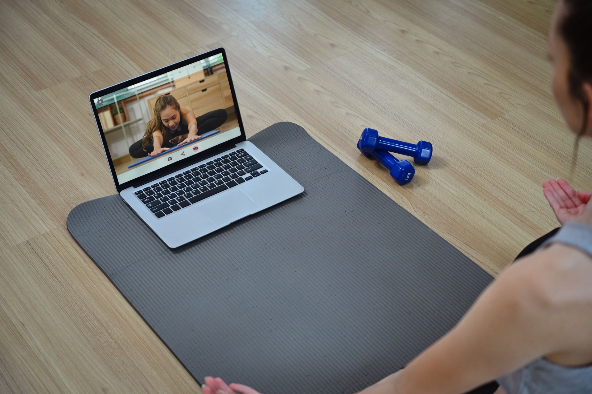 Sporty young woman doing online yoga watching training class online on laptop
